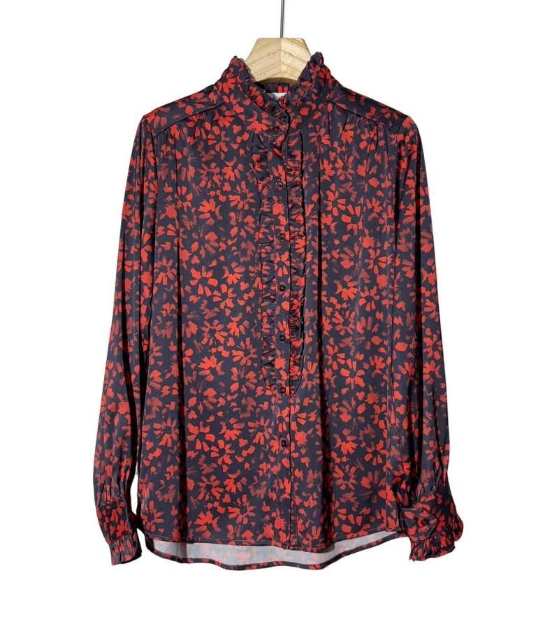 Camisa de manga larga abotonada con estampado floral rojo y negro colgada en una percha de madera.