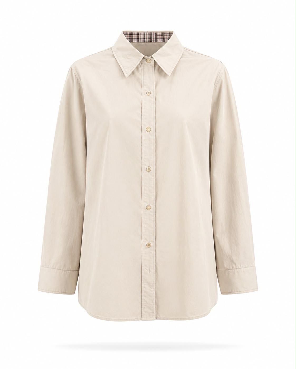 Camisa beige de manga larga con botones y cuello de pico sobre fondo blanco.