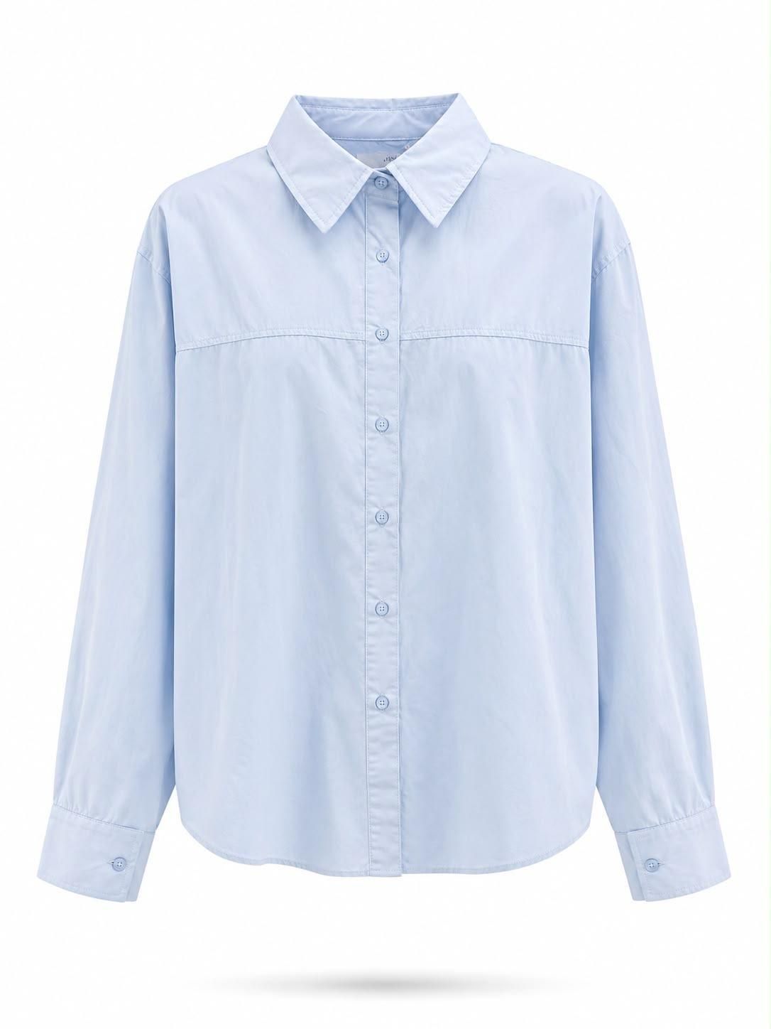 Camisa de vestir azul claro abotonada con cuello y mangas largas, mostrada de frente sobre un fondo blanco.