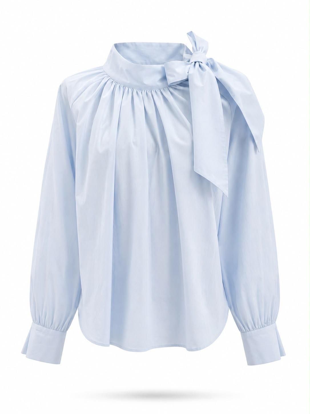 Blusa azul claro de manga larga con cuello con volantes y lazo en el cuello.