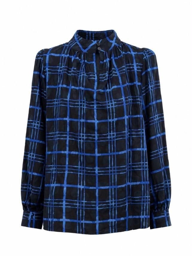 Blusa negra de manga larga con estampado de cuadros azules y cuello alto con volantes.