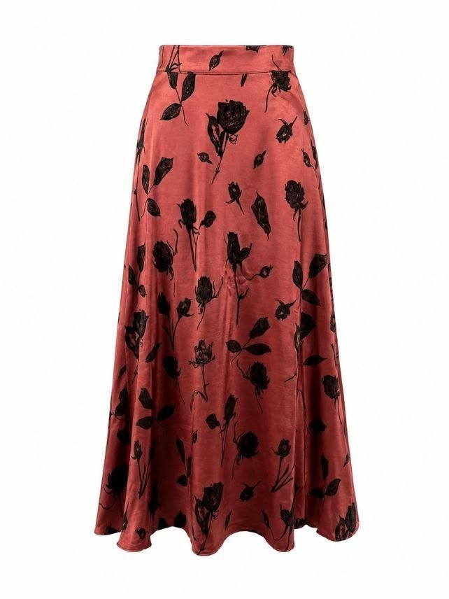 Falda larga color coral con estampado floral negro y bajo acampanado.