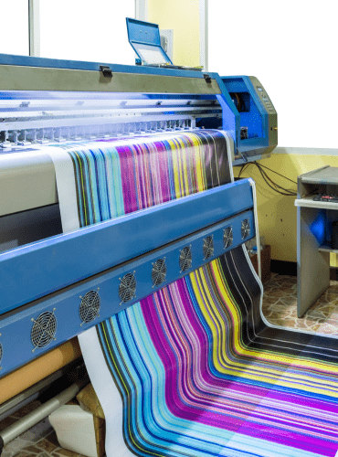 Impresora de gran formato que imprime telas a rayas de colores.