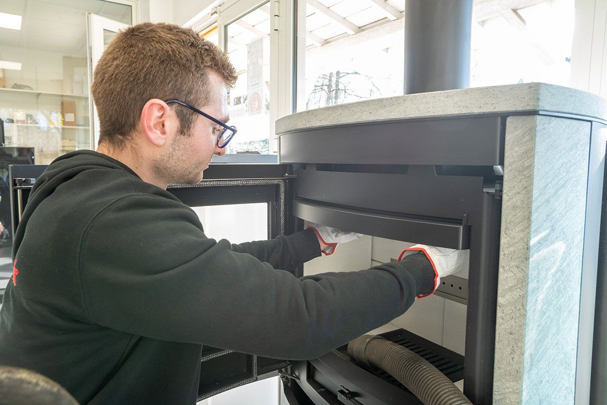Homme qui ramone un poêle.