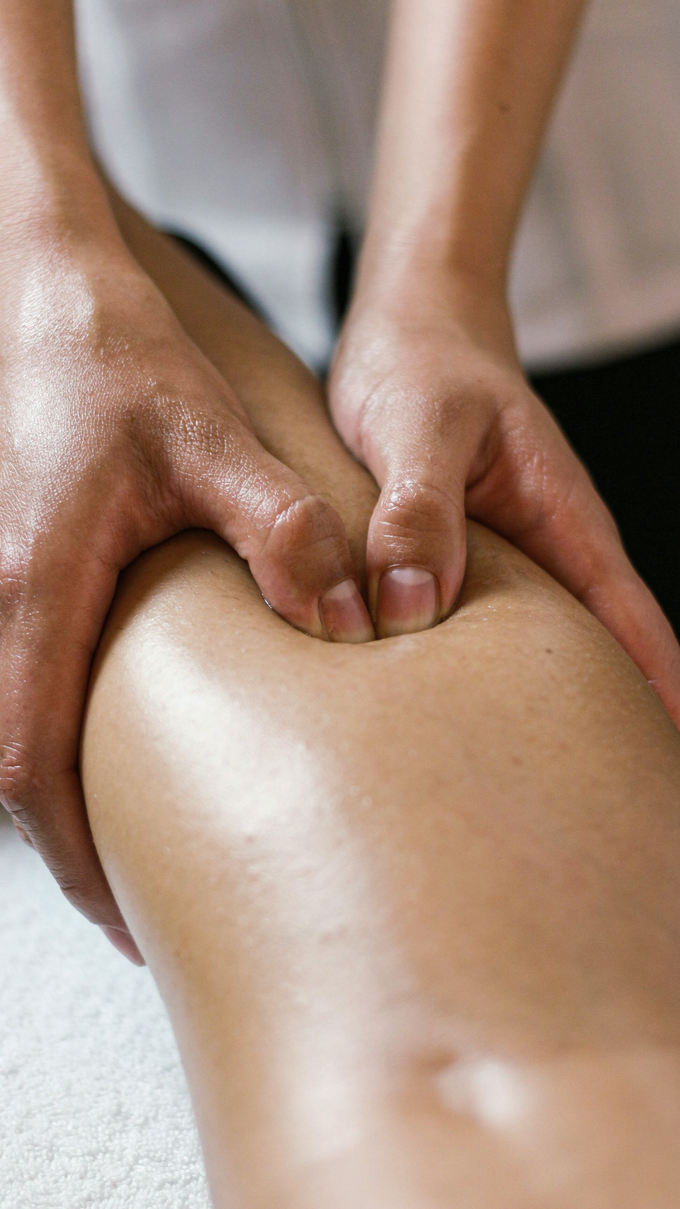 Manos que masajean la parte superior de la espalda de una persona, con aceite sobre la piel.