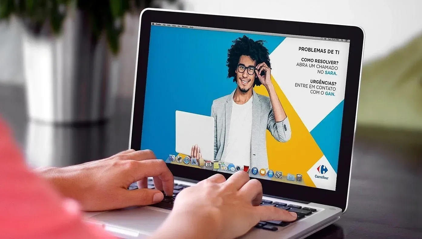 Una persona está escribiendo en una computadora portátil con una imagen de un hombre en la pantalla.