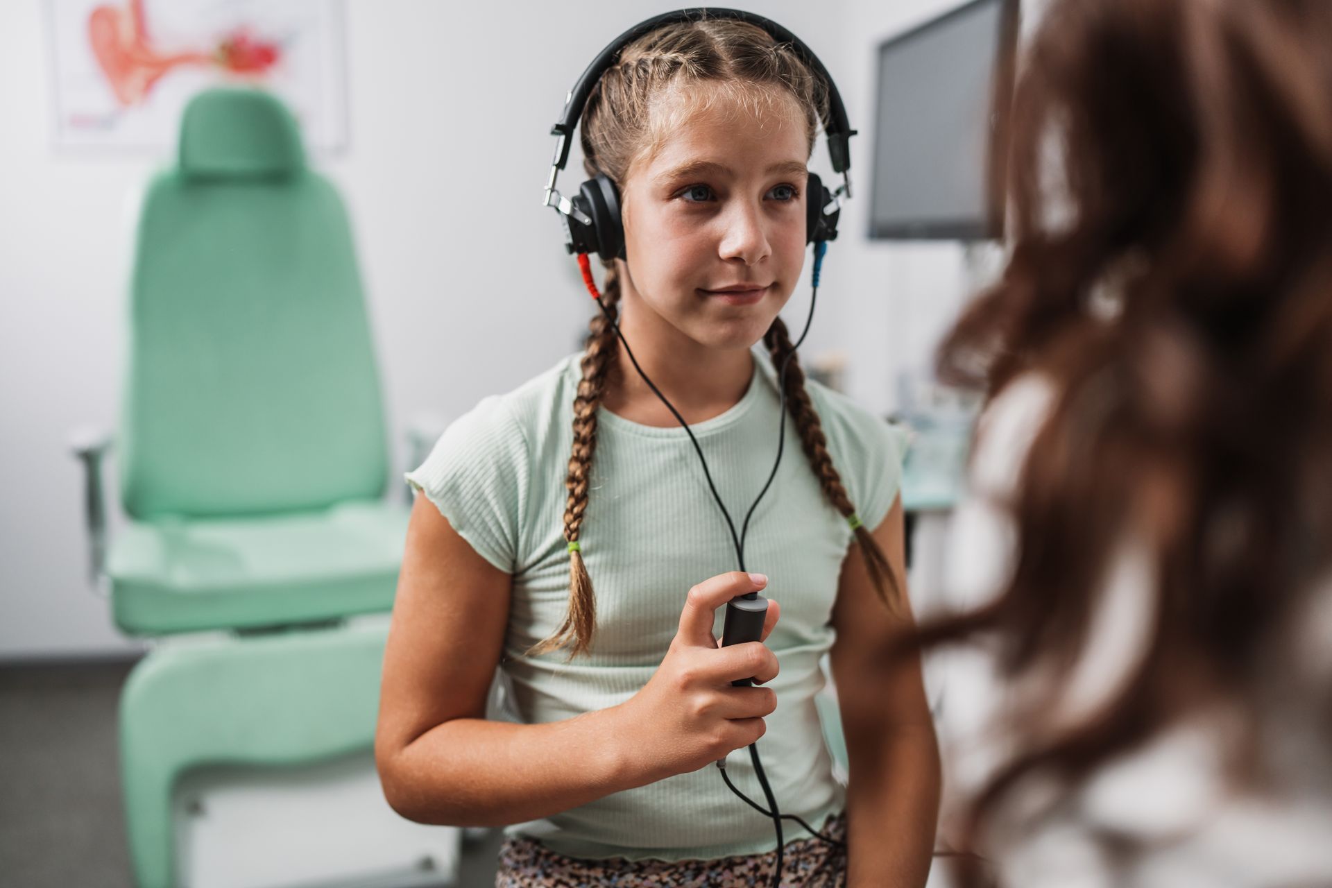 Jeune fille avec des écouteurs réalisant un bilan auditif