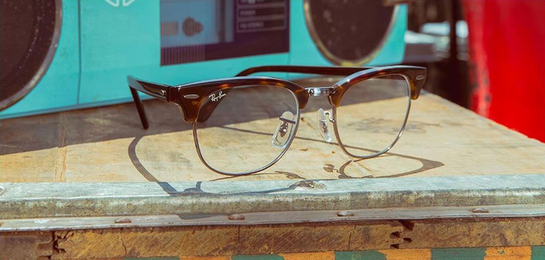 Des lunettes posées sur une surface usée, une radio turquoise en arrière-plan.