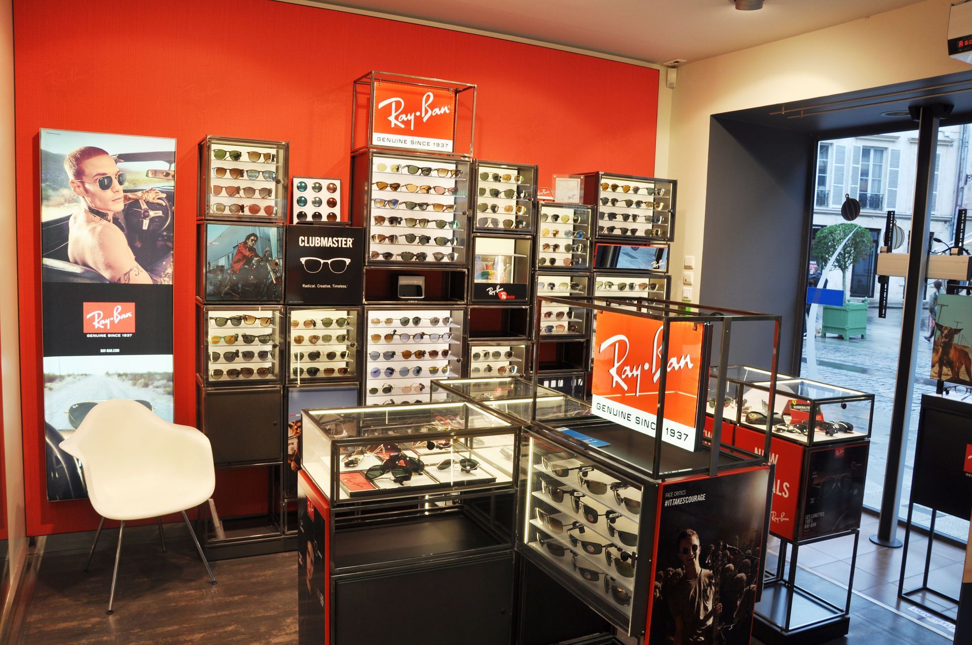 Présentoirs de lunettes de soleil dans un corner Ray-Ban. Présentoirs rouges et noirs avec différents modèles.