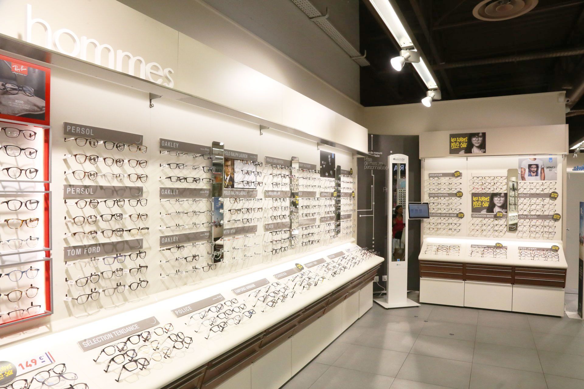 Vitrine d'optique avec lunettes à vendre. Murs blancs, éclairage vif.