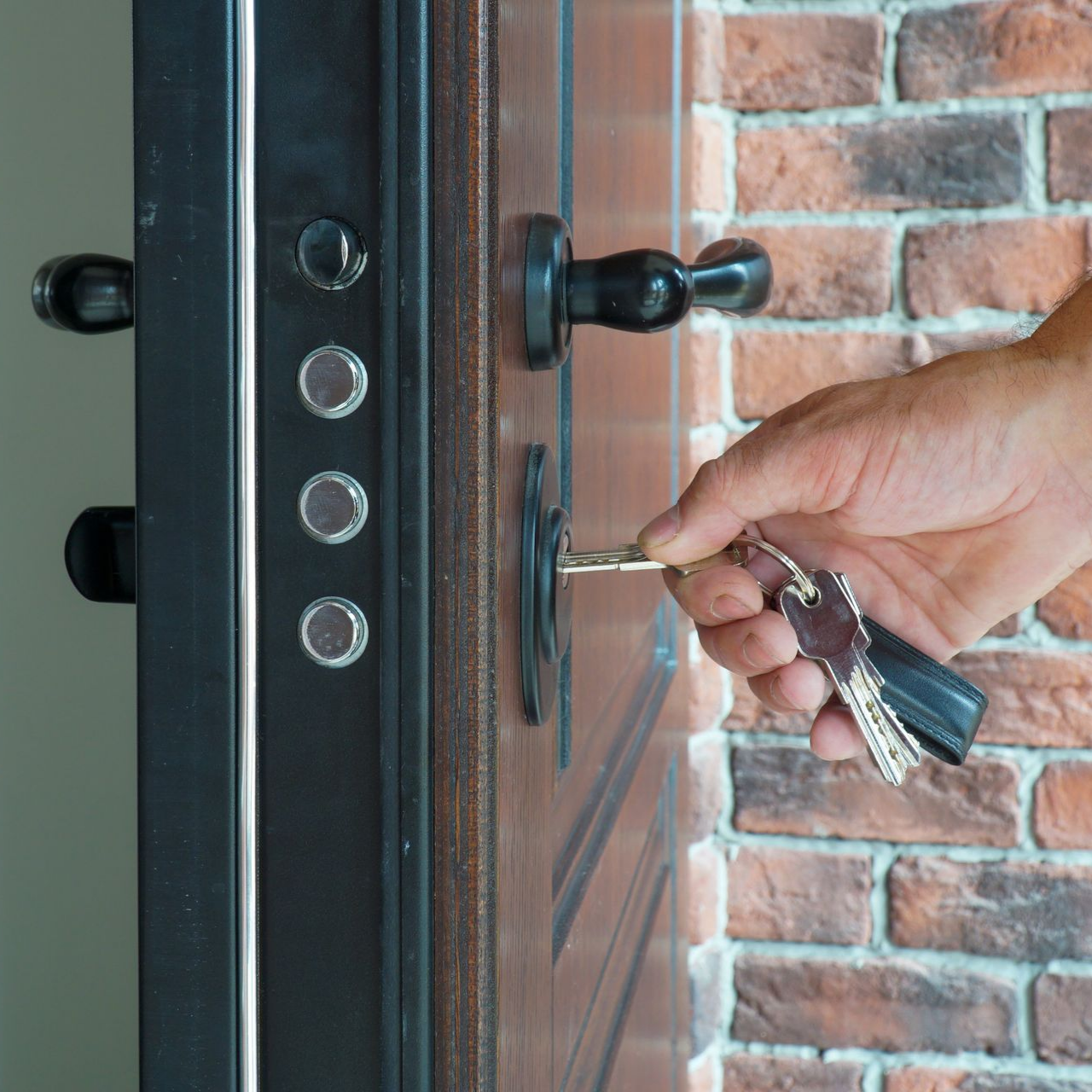 Homme mettant une clé dans une porte blindée