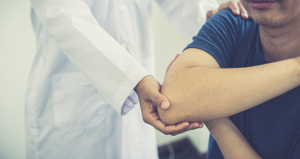 Médico examinando el codo del paciente, en el interior.