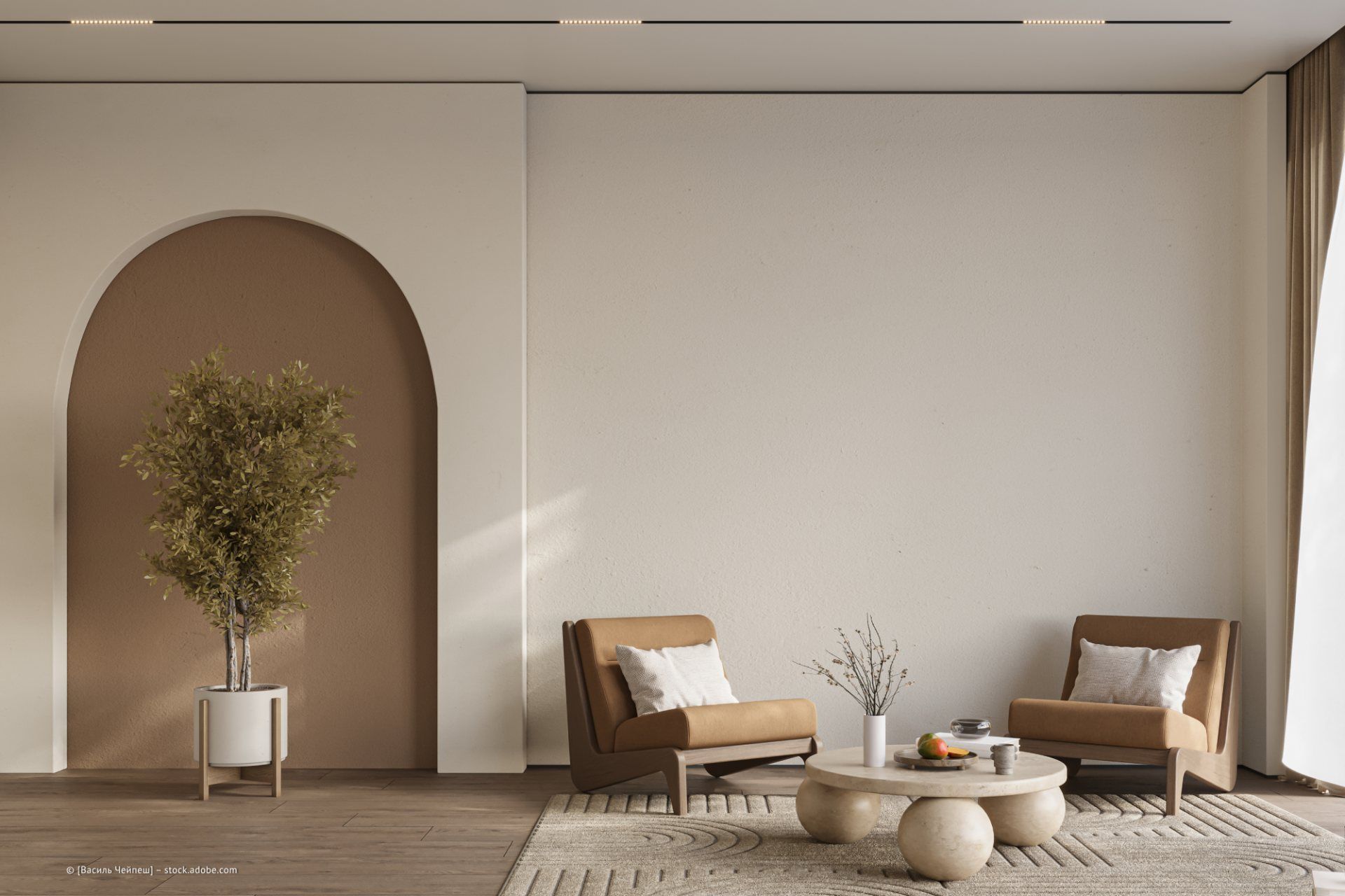 Wohnzimmer mit zwei hellbraunen Sesseln, einem runden Couchtisch und einem Topfbaum vor einer neutralen Wand.