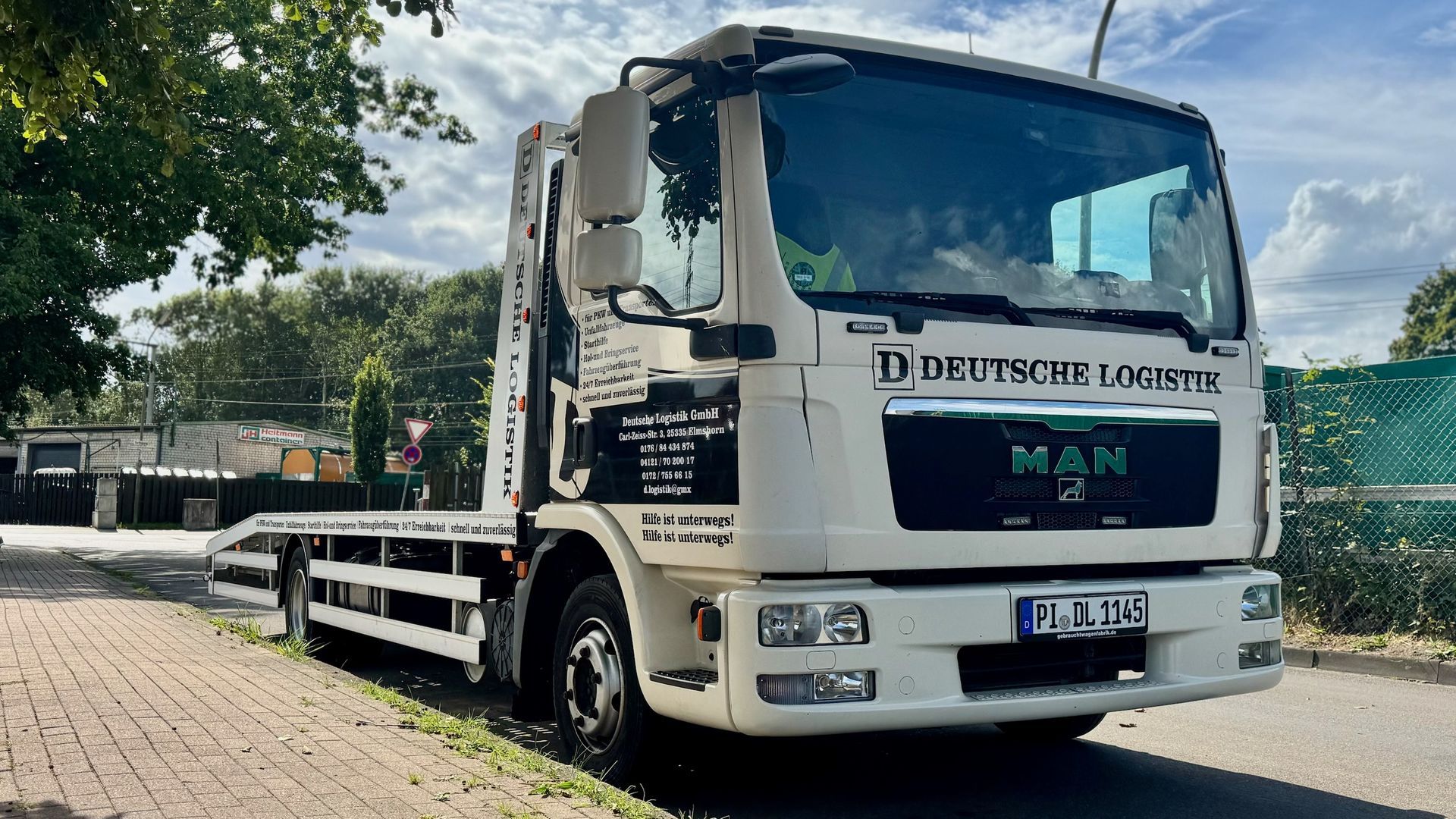 Modernes Büro mit Schreibtischen, Stühlen und großen Fenstern mit Blick auf die Stadt.