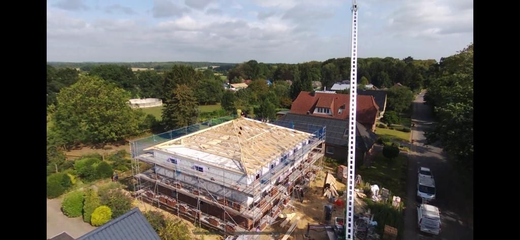 Eine Luftaufnahme eines im Bau befindlichen Gebäudes mit einem Kran im Vordergrund.