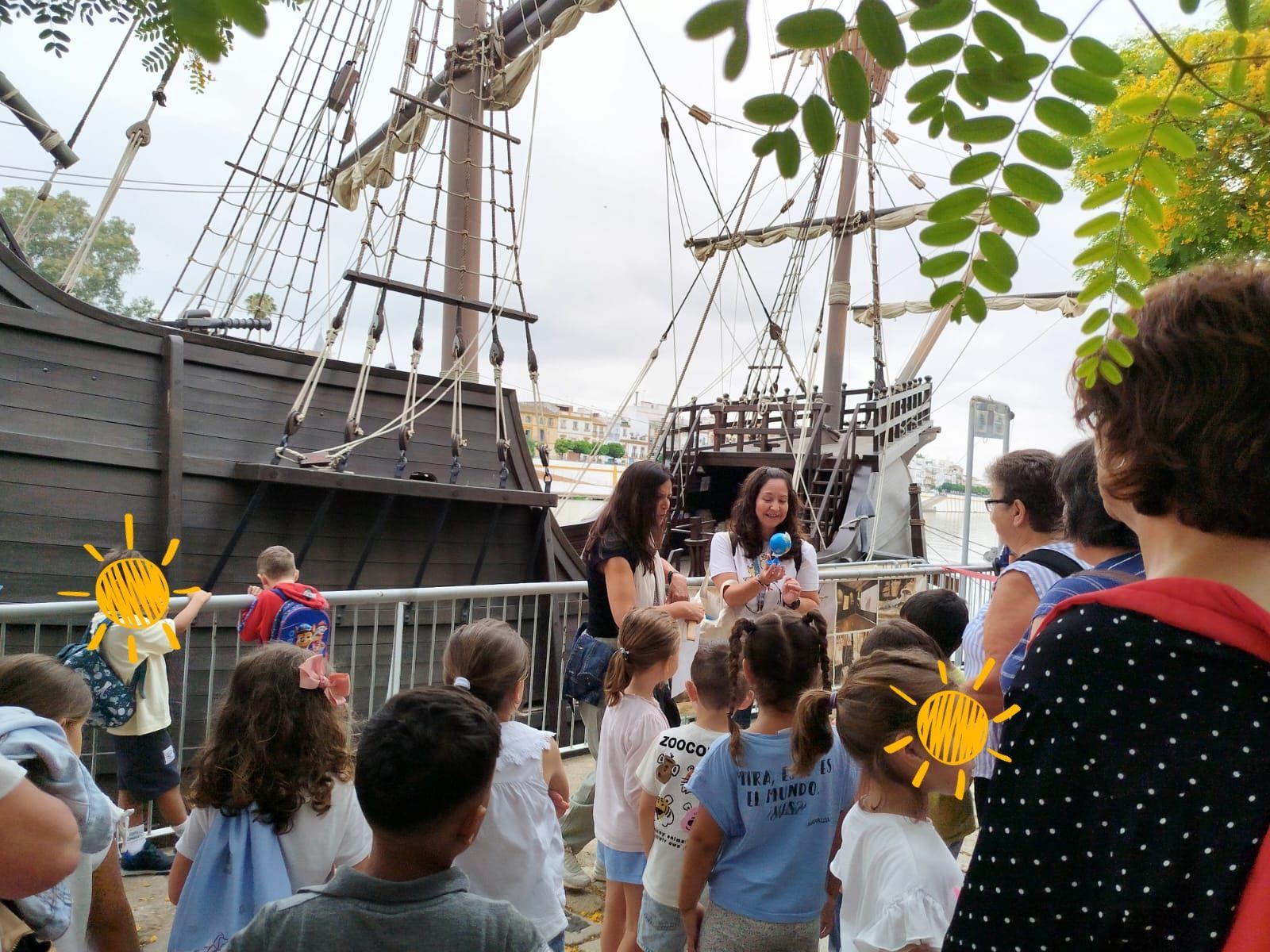 Un grupo de niños está parado frente a un barco pirata.