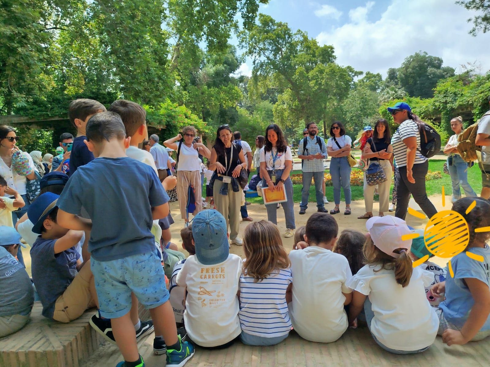 Un grupo de niños está sentado en el suelo en un parque.