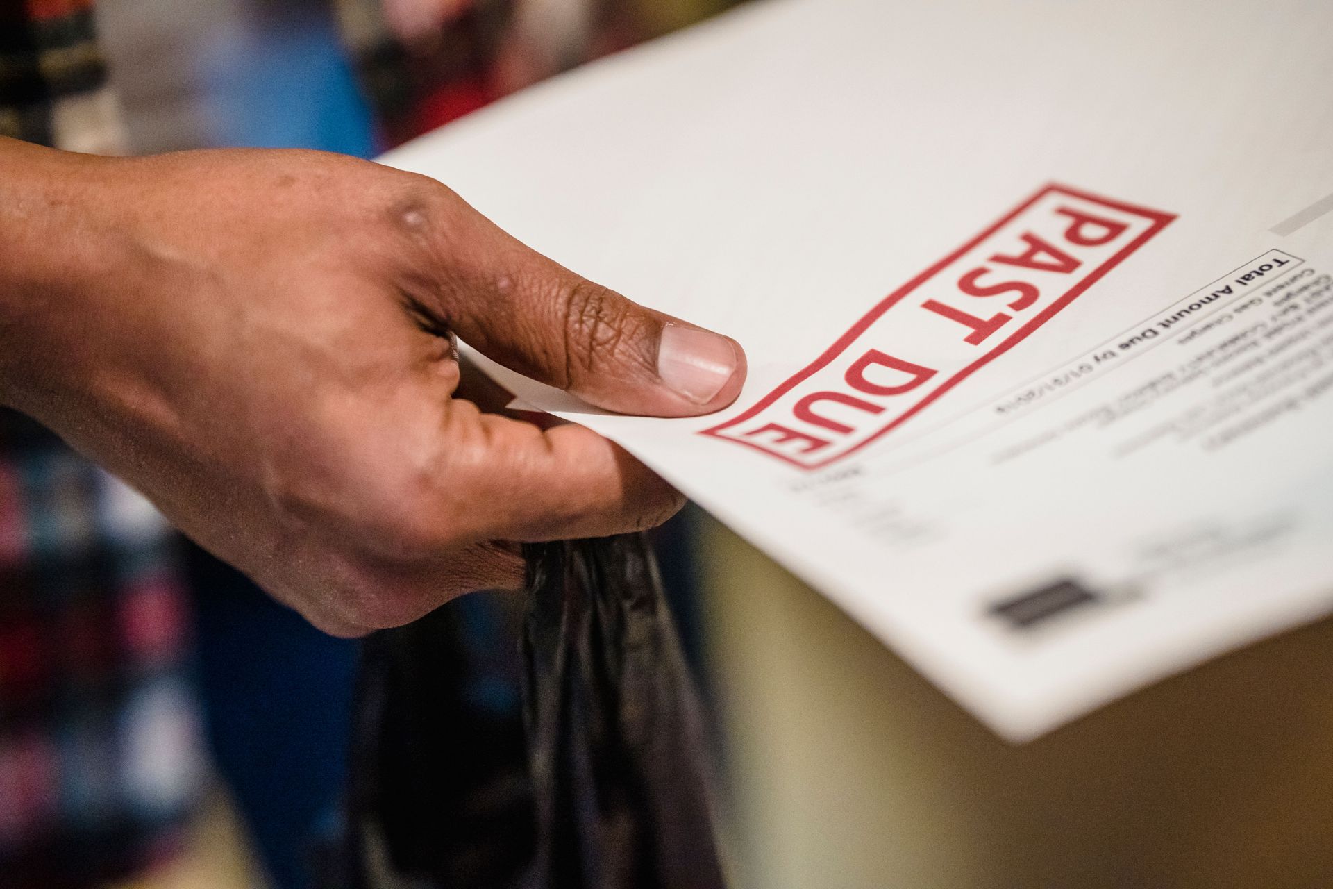 Mano sosteniendo una papeleta de voto blanca sellada con la marca roja “POST DU”.
