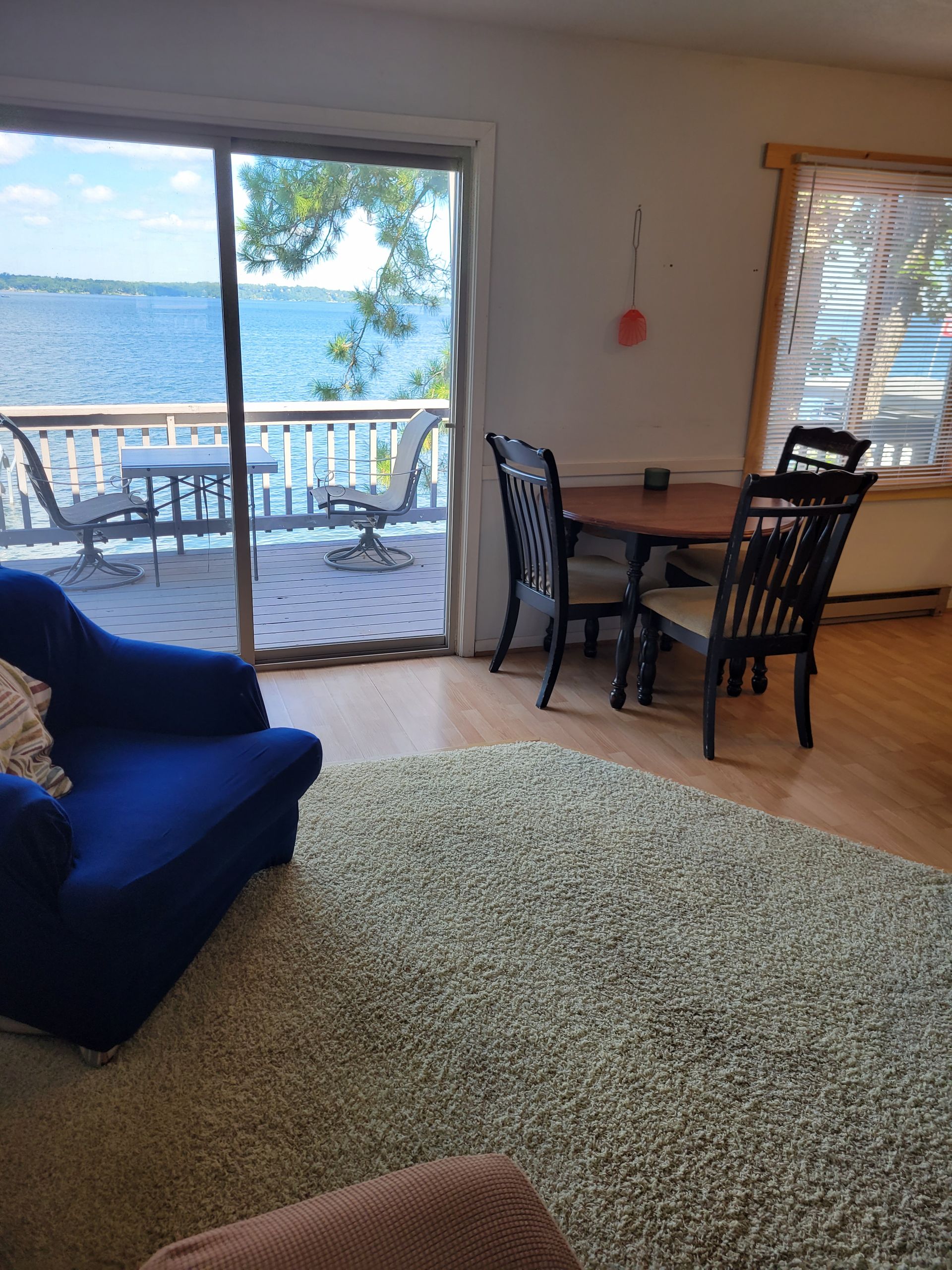 A living room with a table and chairs and a view of the water