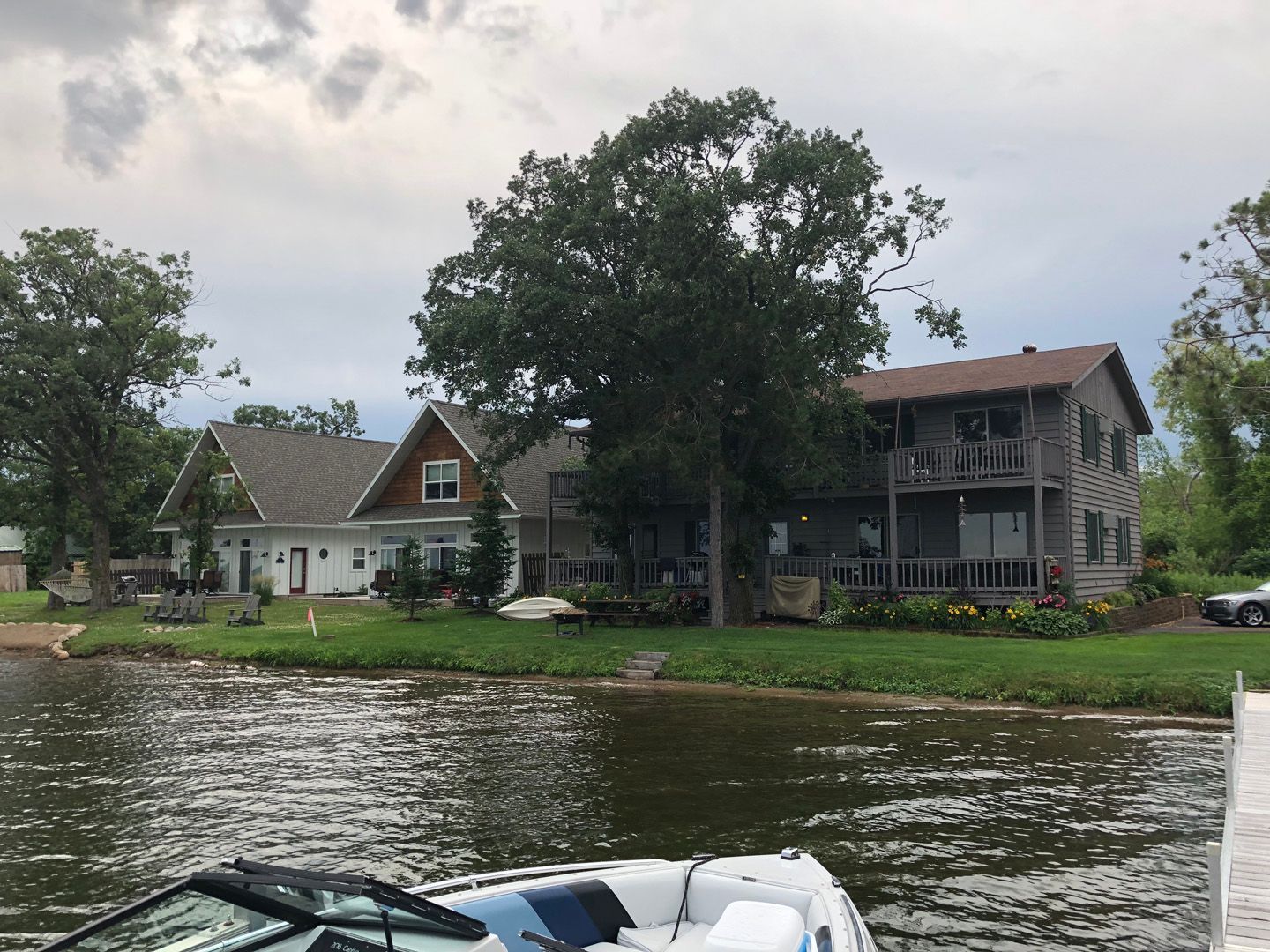 A boat is docked in front of a house on a lake