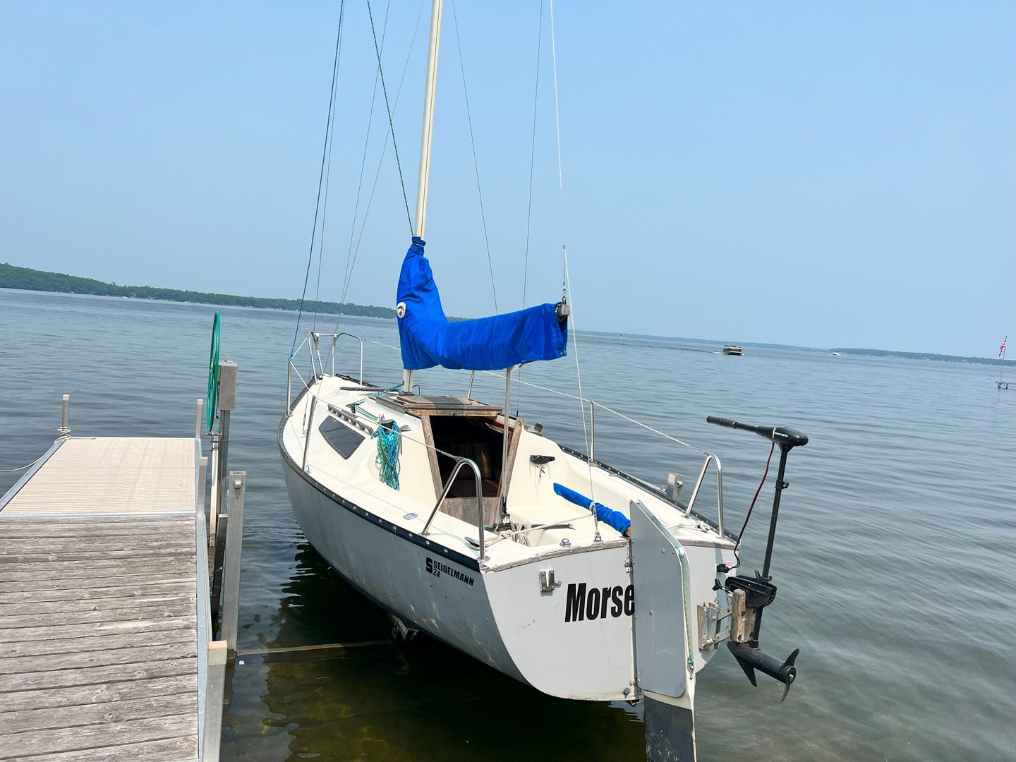 A small sailboat named morsa is docked at a dock