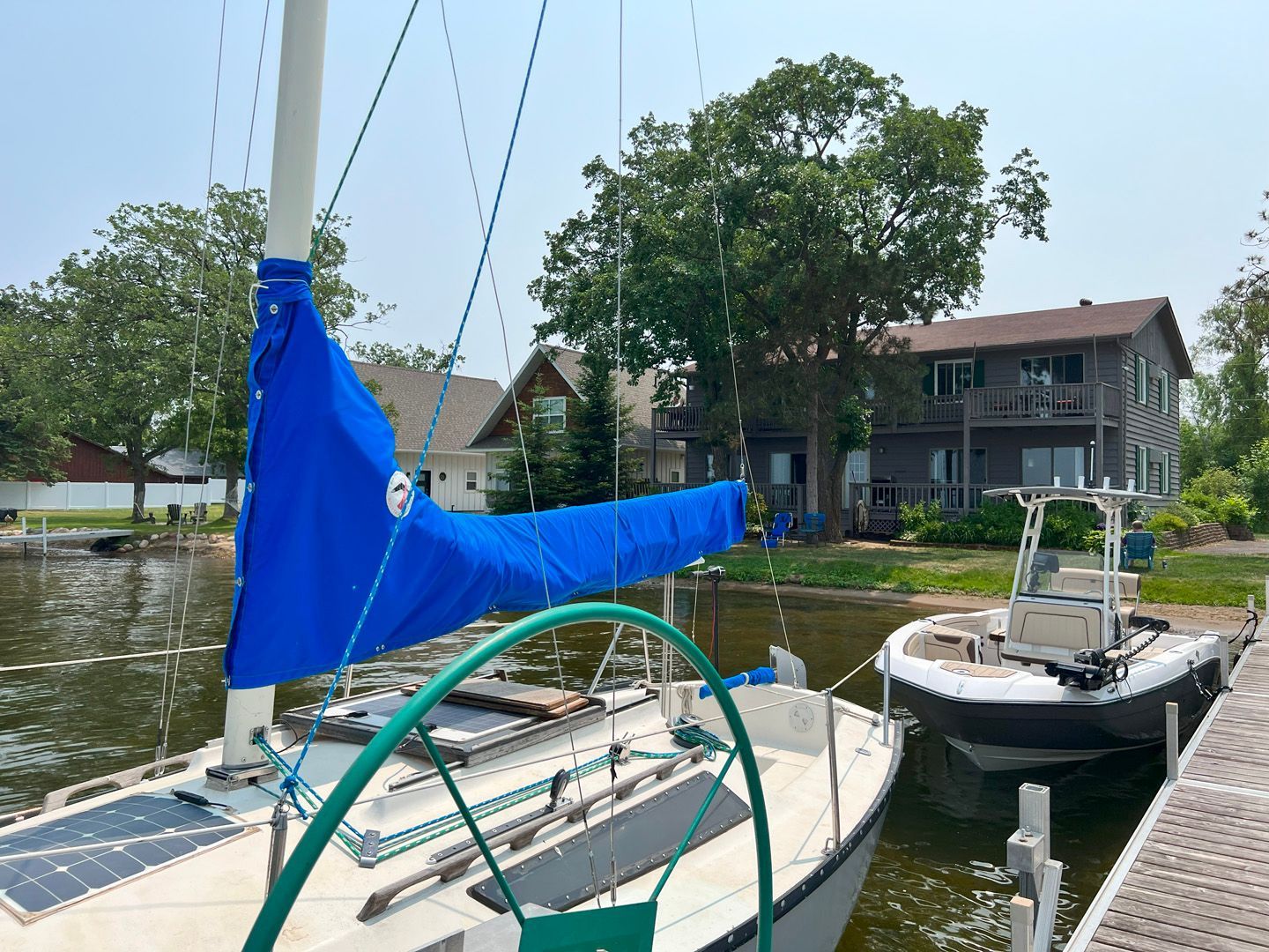 A sailboat with a blue sail is docked at a dock.