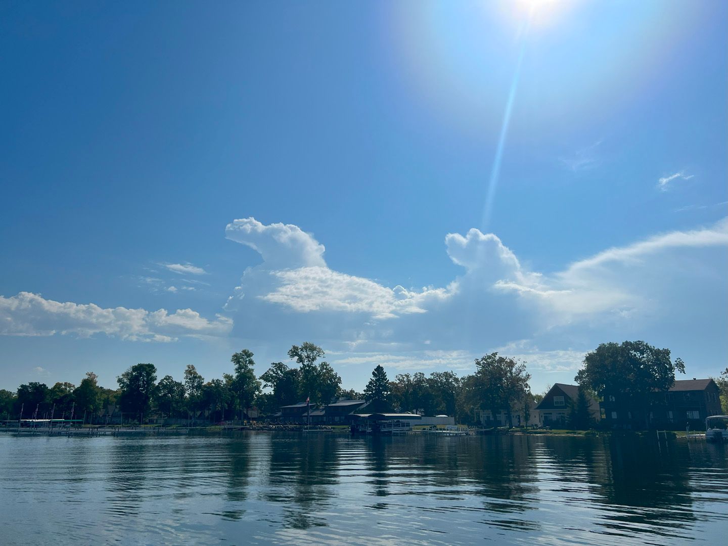 A lake with a heart shaped cloud in the sky