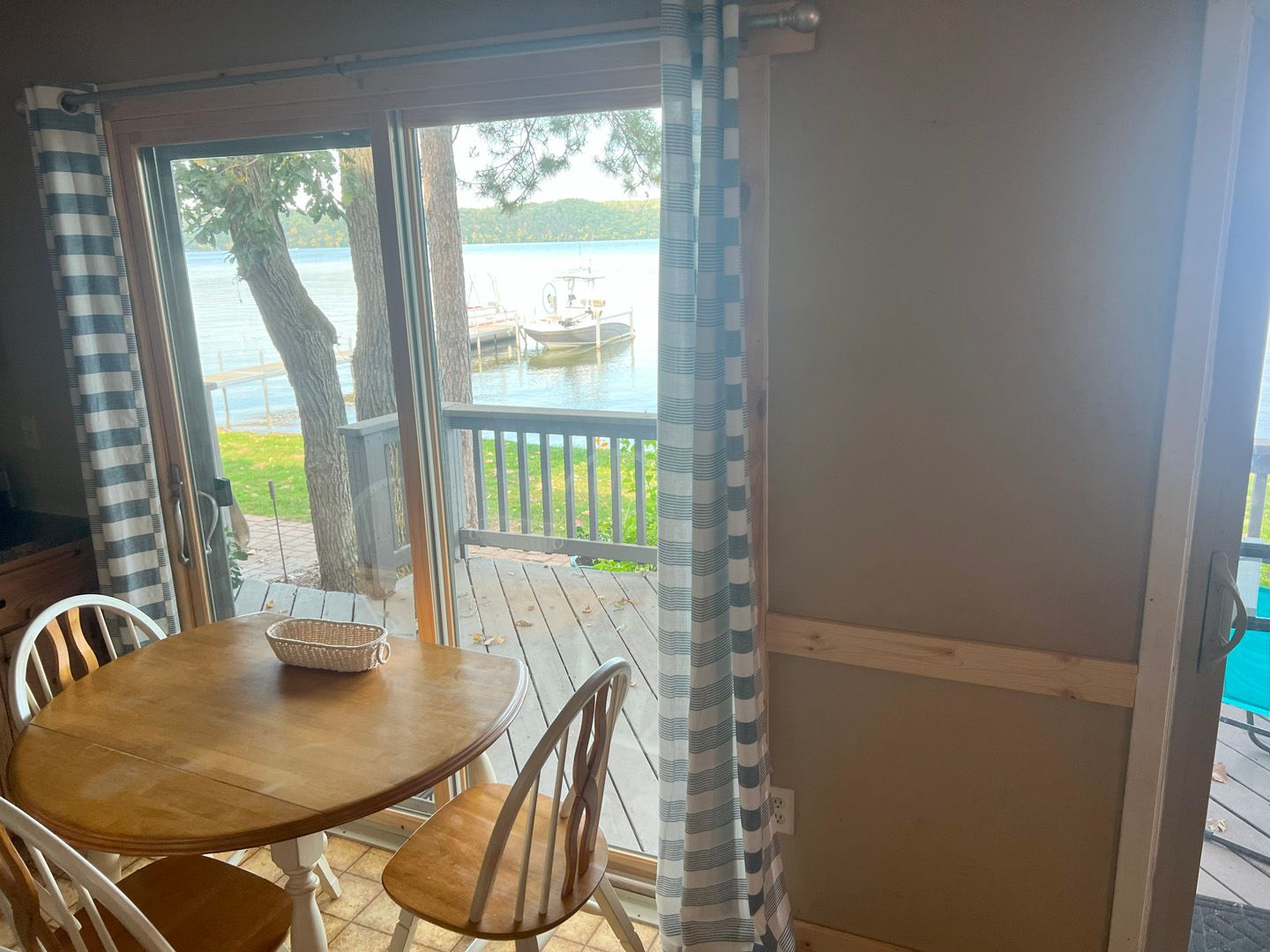 A dining room with a table and chairs and a view of a lake.