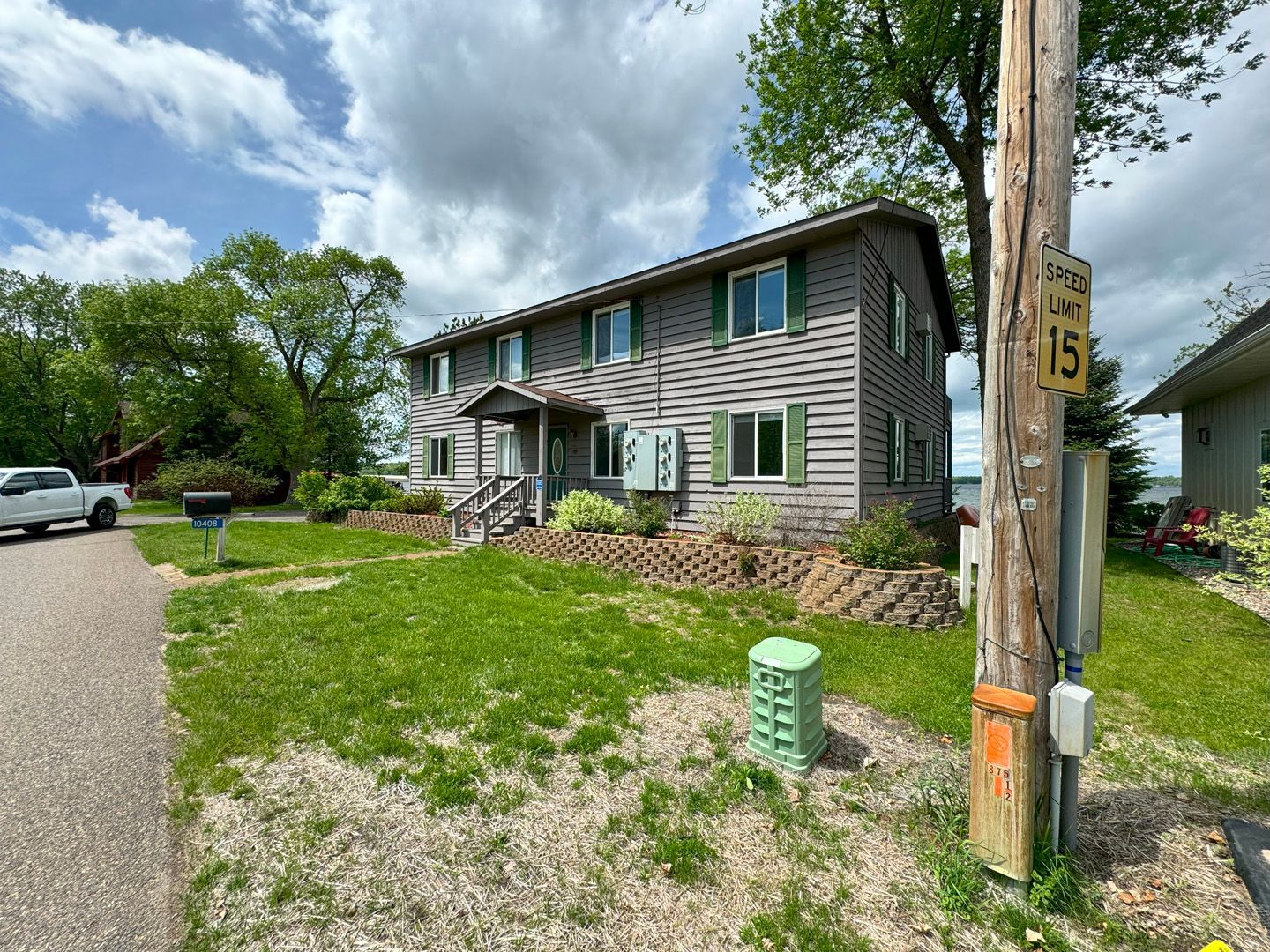 A large house with a lot of windows is sitting on top of a lush green hill.