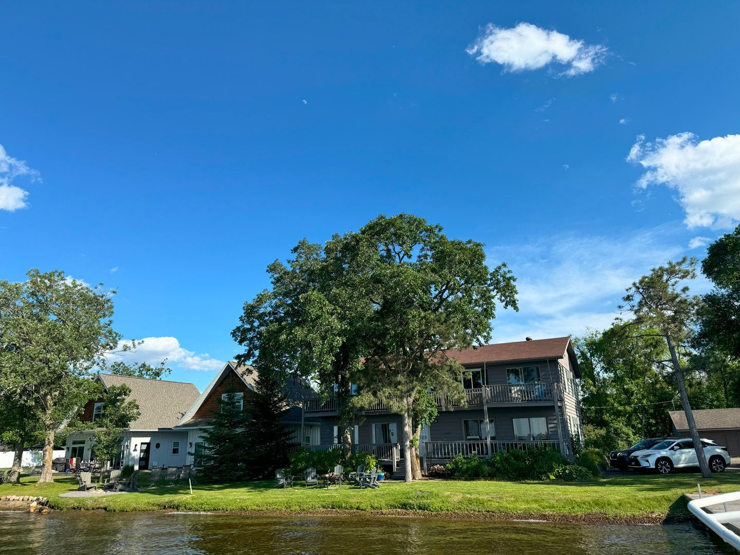 A house is sitting next to a body of water on a sunny day.