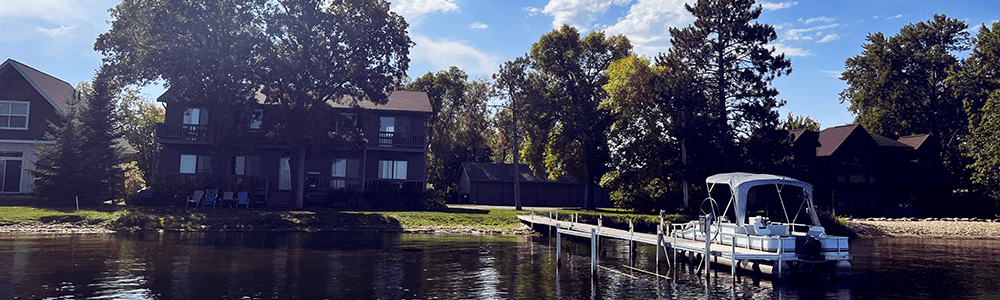 A boat is docked in the water in front of a house.