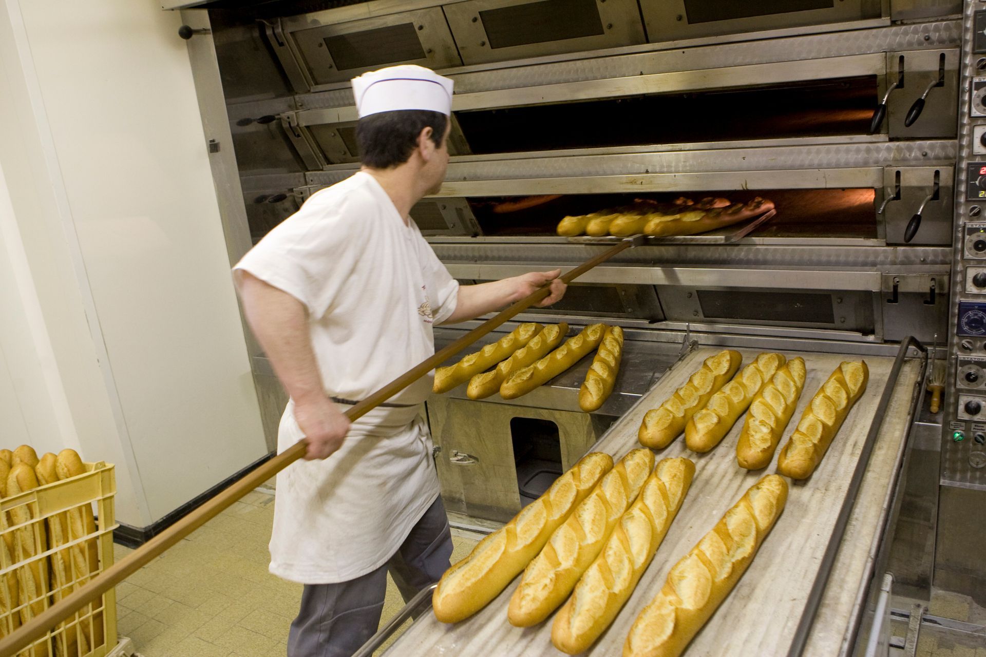 Boulanger en train de cuire des baguettes