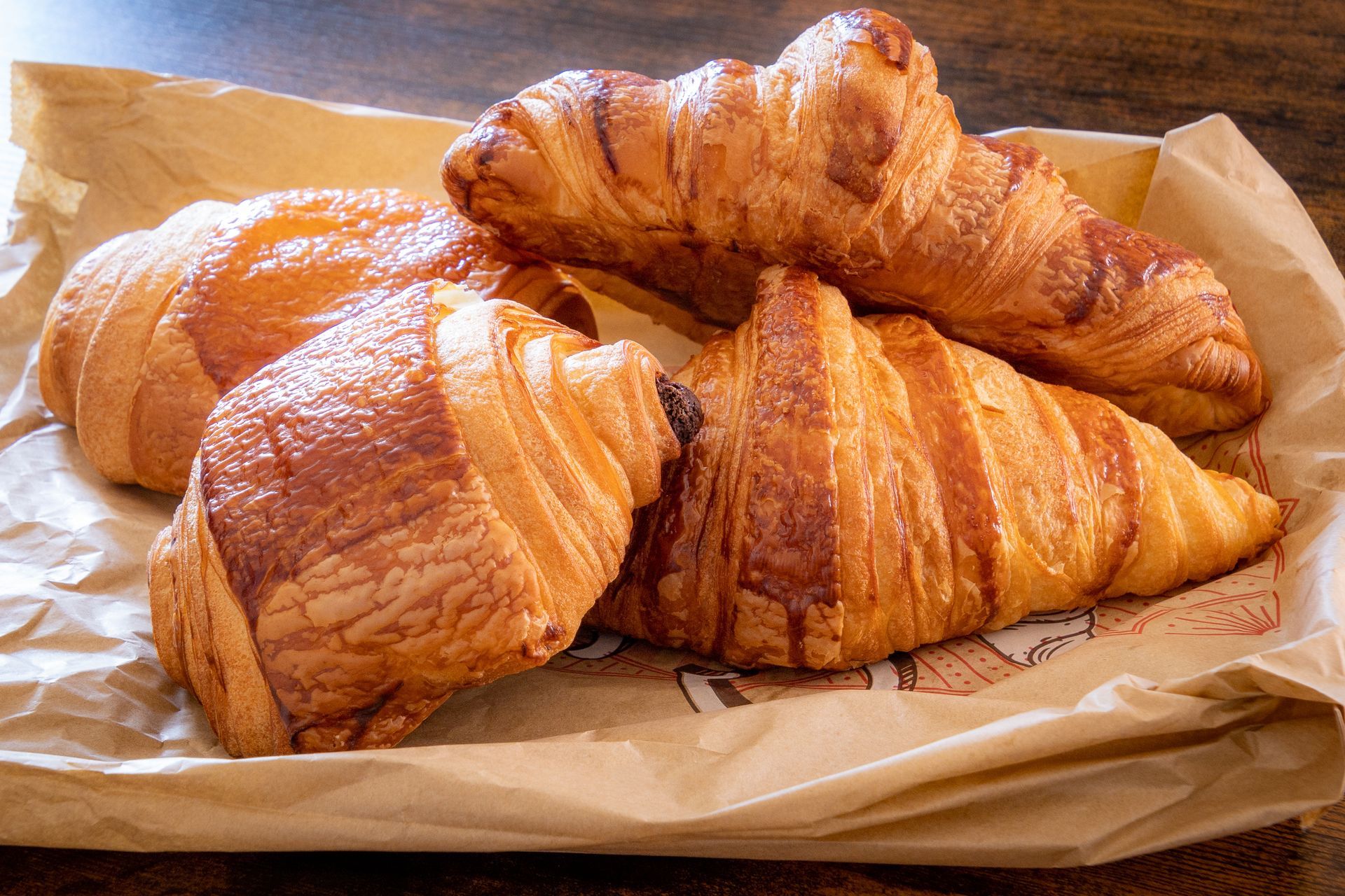 Des croissants dorés sur une feuille de papier brun.