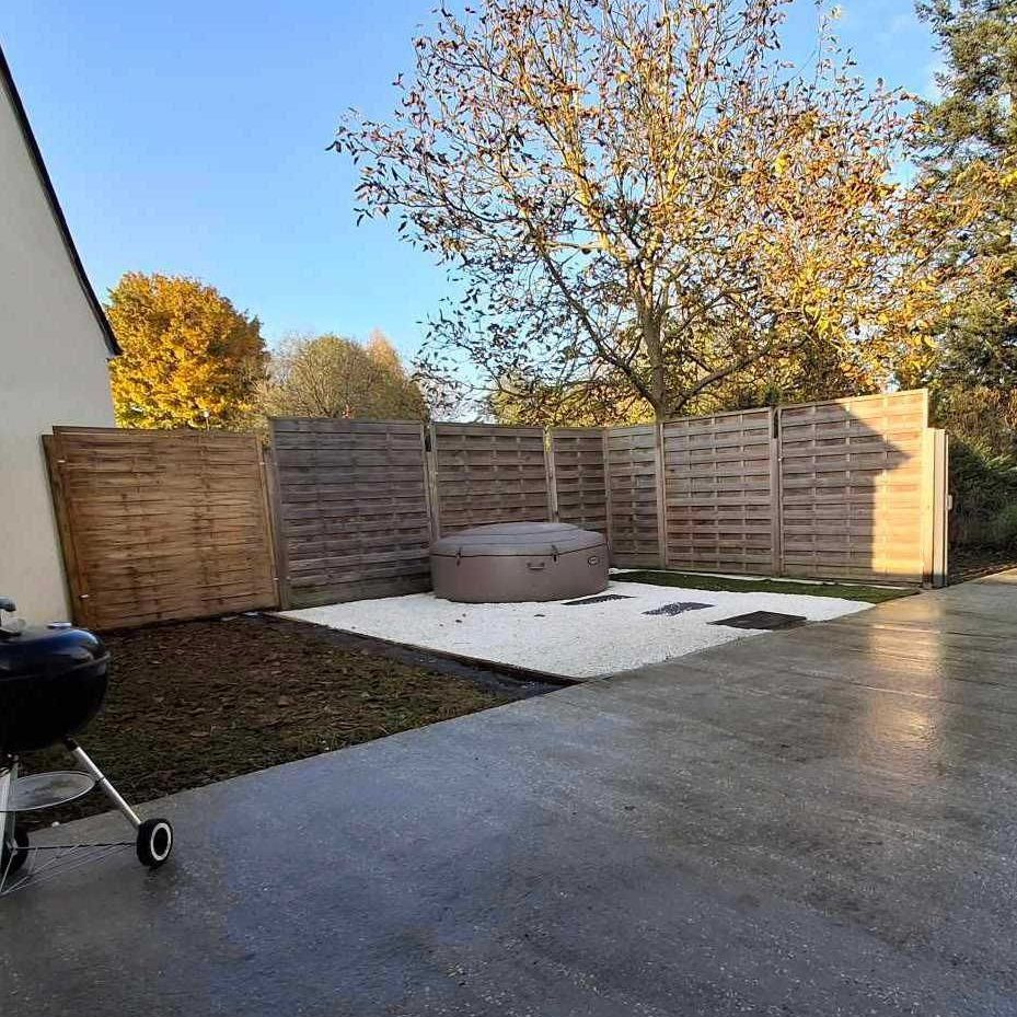 Création d'un espace extérieur sur du gravier blanc entouré de panneaux pour un SPA.
