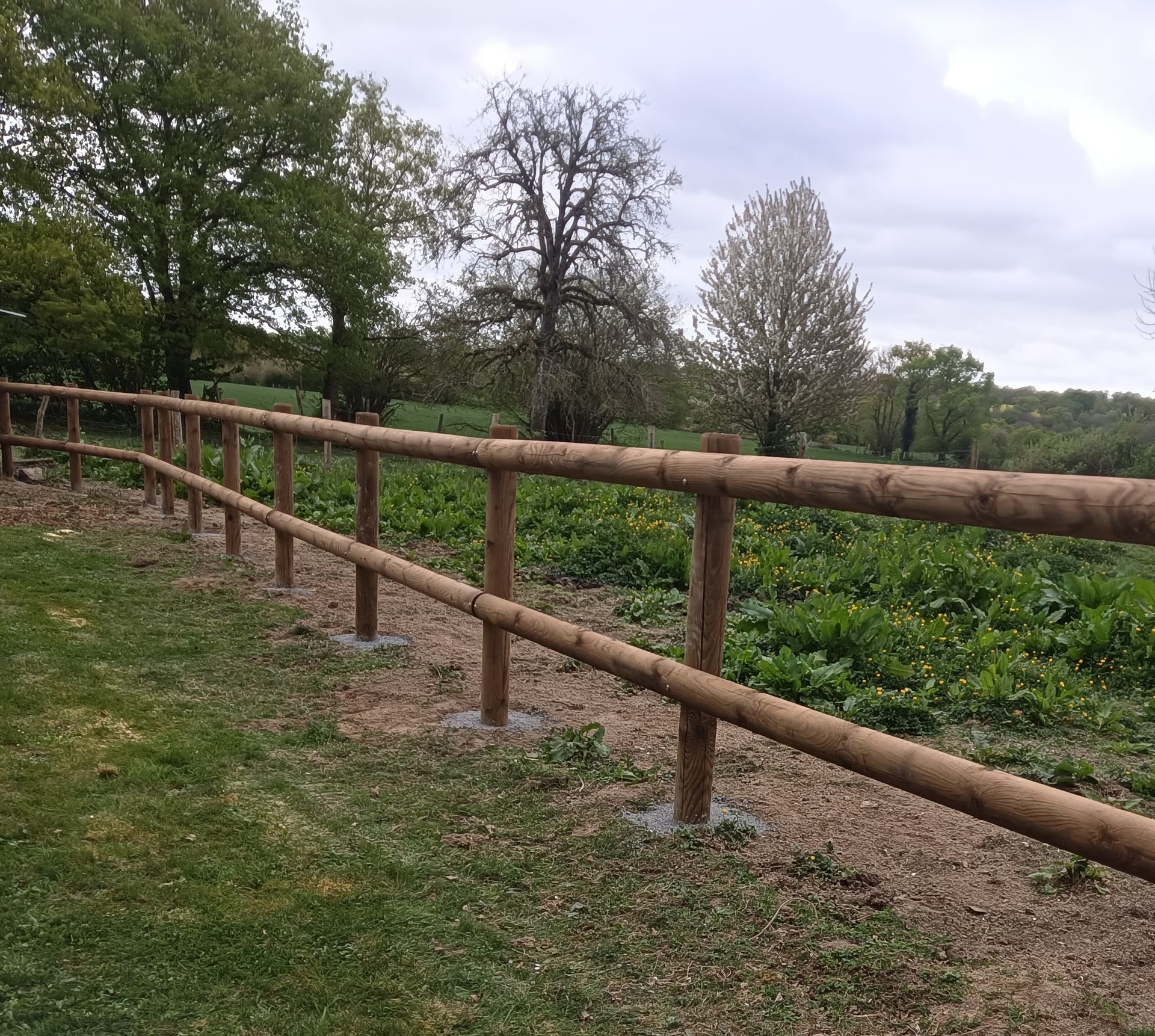 Clôture en grillage avec une bâche au sol.