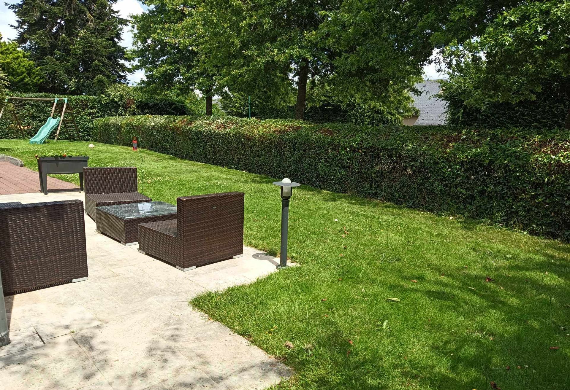 Taille d'une haie près d'une terrasse.