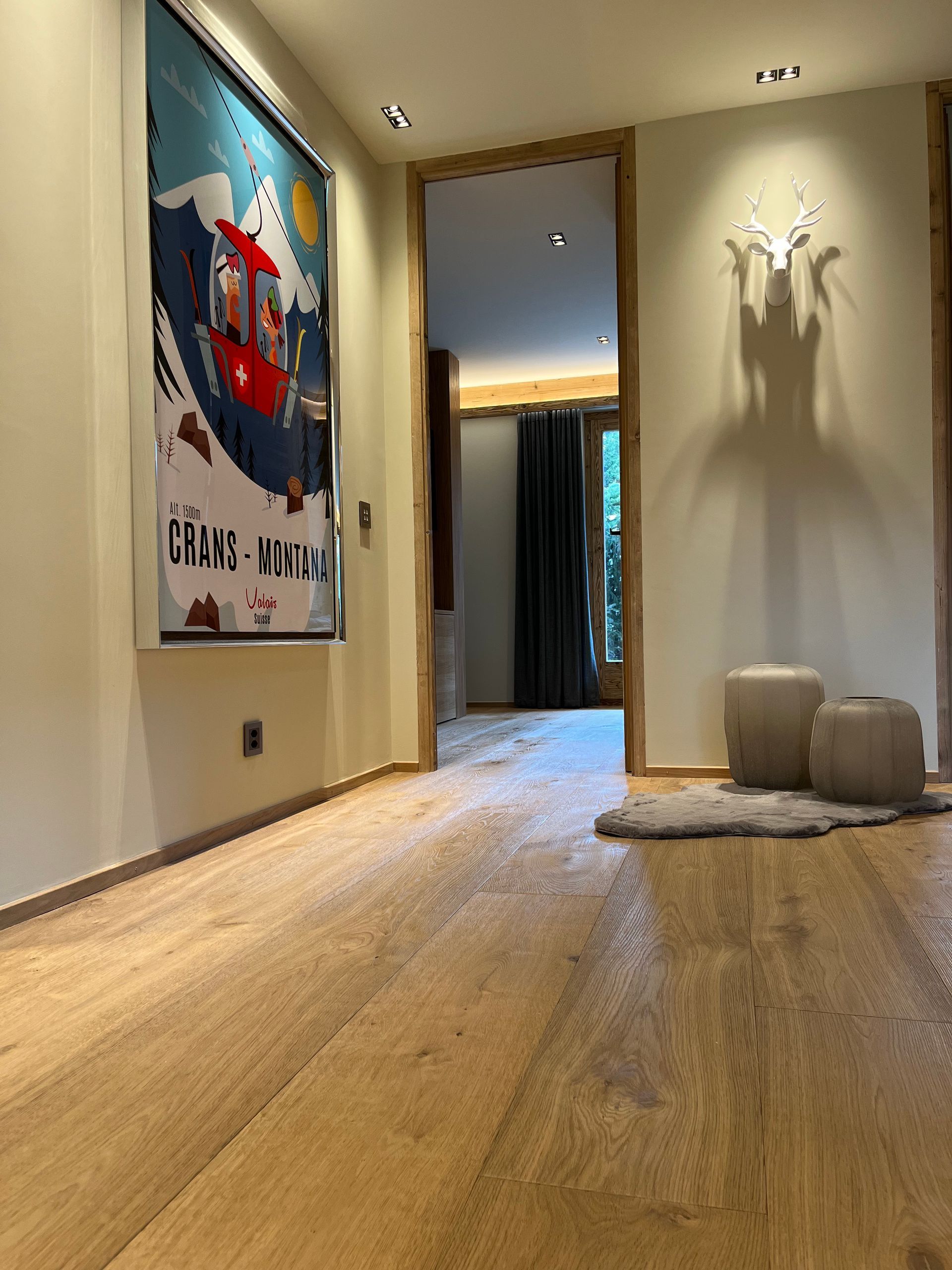 Pièce chaleureuse aux tons bruns avec canapé d'angle en cuir, sculpture de mouton et étagères à livres. Une enseigne lumineuse indique « bibliothèque du futur ».