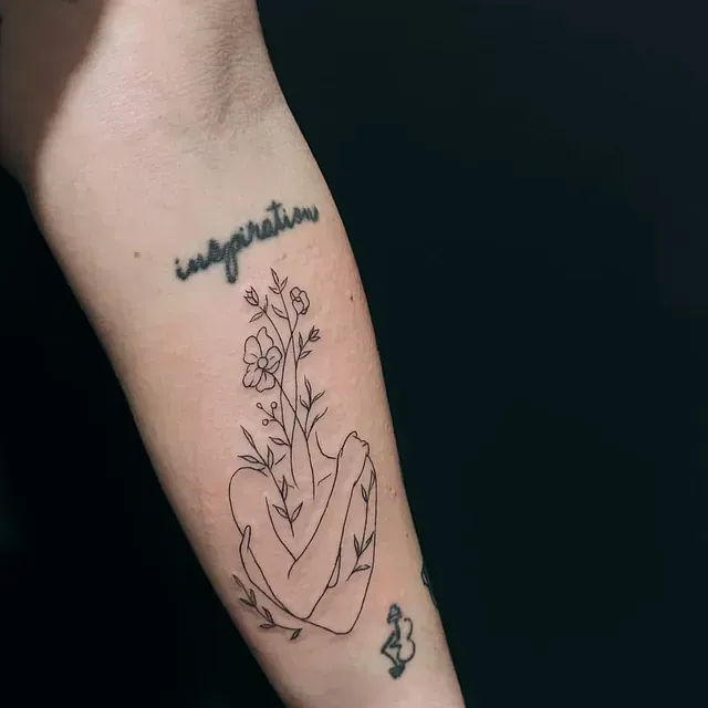 Una mujer tiene un tatuaje de una mujer sosteniendo flores en su antebrazo.