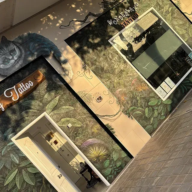 Una tienda de tatuajes con un gato de Cheshire en la pared.