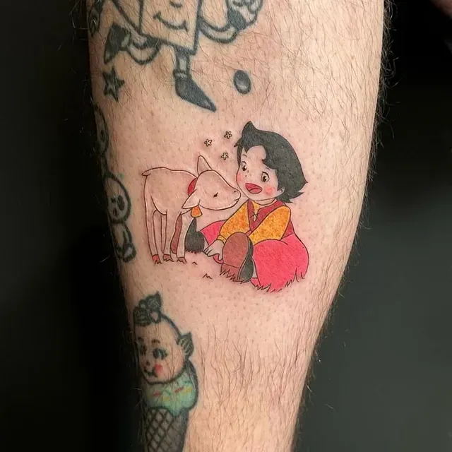 Una persona tiene un tatuaje de Heidi y su cabra en la pierna.
