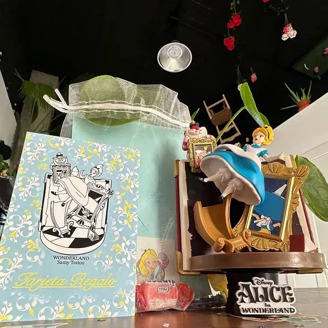 Una figura de Alicia en el país de las maravillas de Disney se encuentra sobre una mesa.