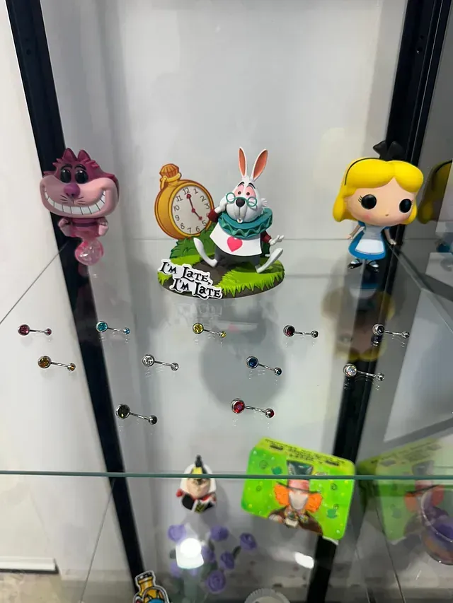 Una vitrina llena de una variedad de juguetes, incluidas figuras de Alicia en el país de las maravillas.