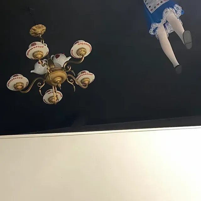 Una lámpara de araña con una imagen de Alicia en el país de las maravillas.