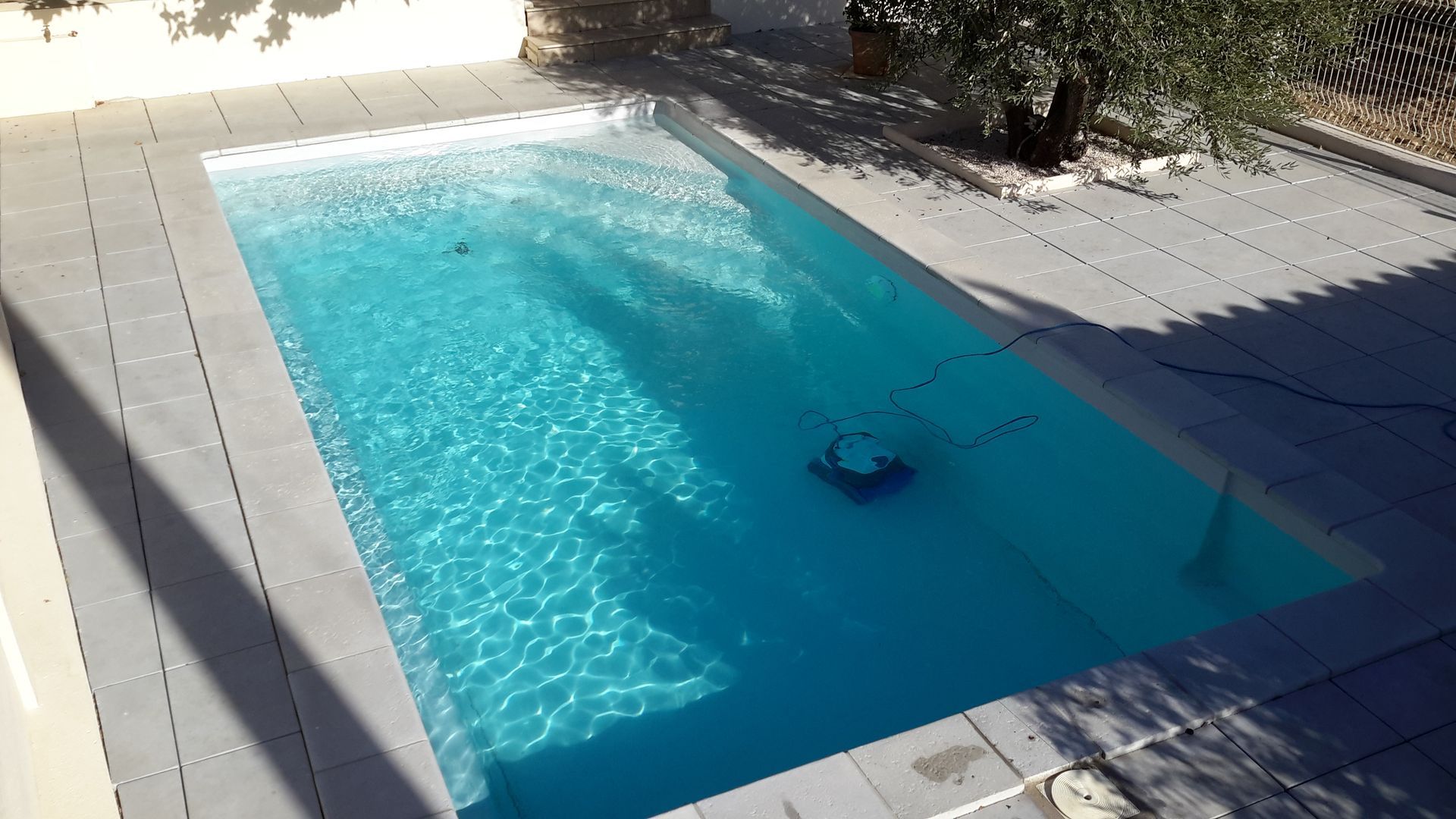 Piscine à coque avec robot nettoyeur