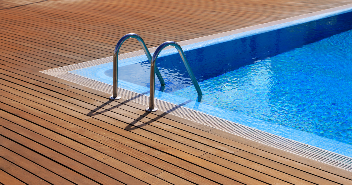 Échelle dans une piscine encastrée dans une terrasse en bois