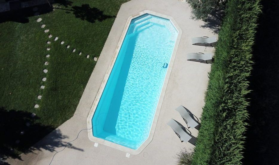 Vue aérienne d'une piscine avec des transats sur le côté