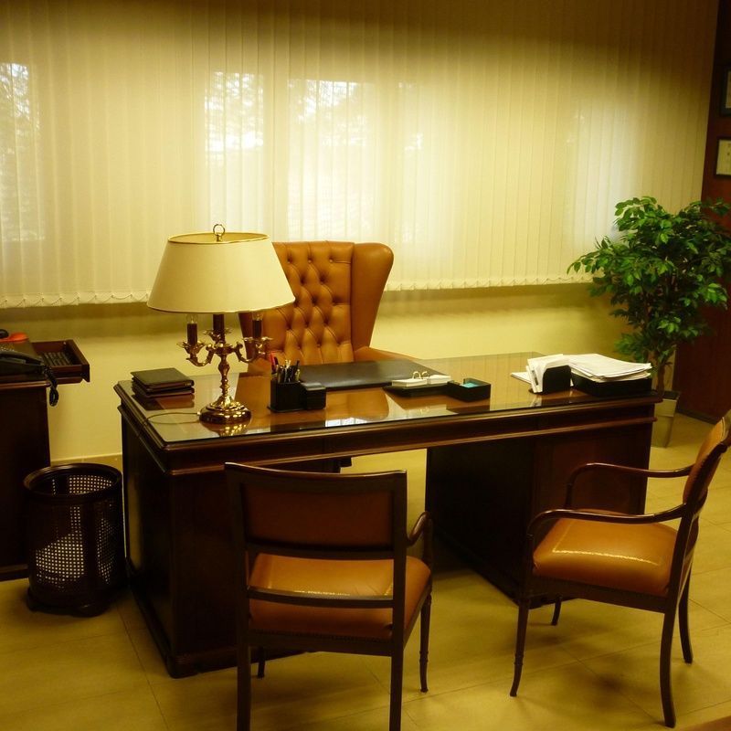 Un escritorio con dos sillas y una lámpara encima.