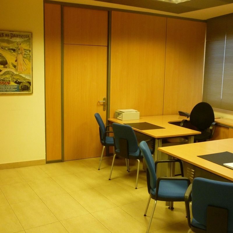 Una habitación con mesas y sillas y un cartel en la pared.