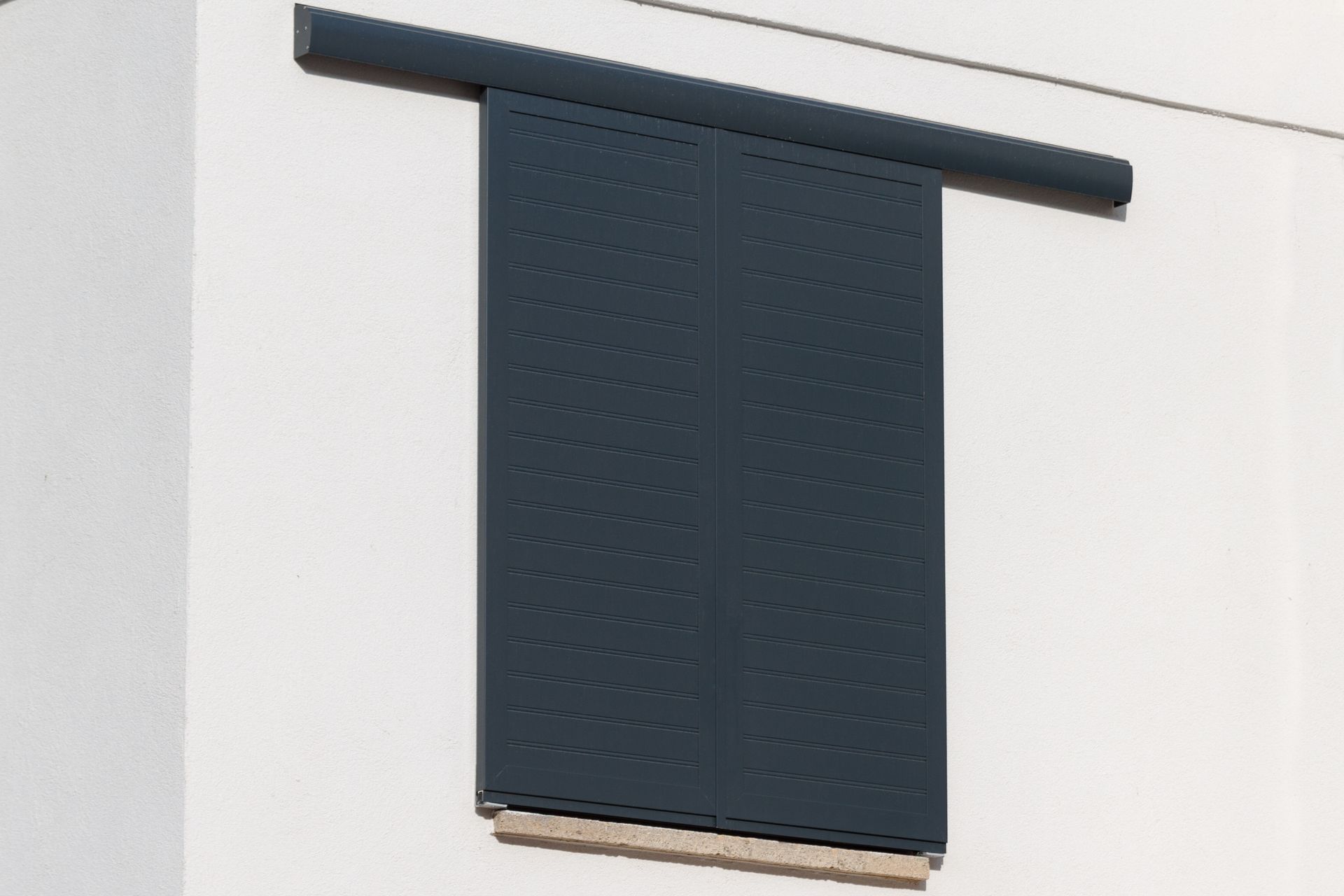 Volets battants noirs fermés.