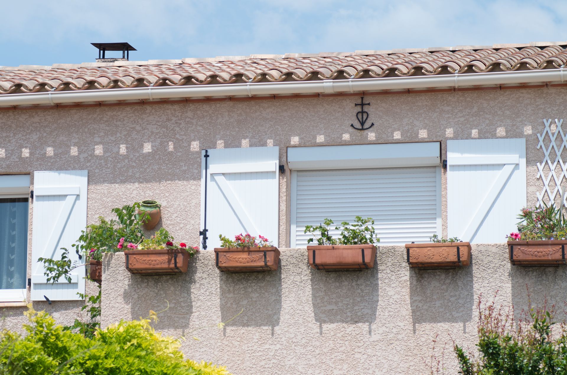 Fenêtres d'une maison avec volets roulants et volets battants.
